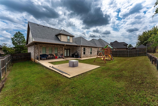 back of property with a playground, a yard, and a patio area