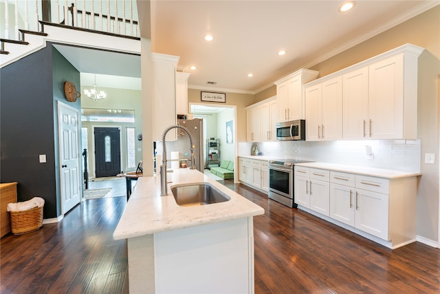 kitchen featuring sink, dark wood-type flooring, white cabinetry, appliances with stainless steel finishes, and crown molding