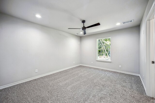 empty room featuring ceiling fan and carpet