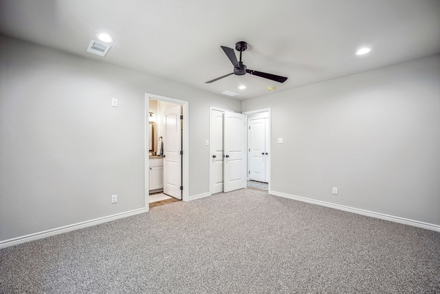 unfurnished bedroom featuring light carpet, ensuite bath, and ceiling fan