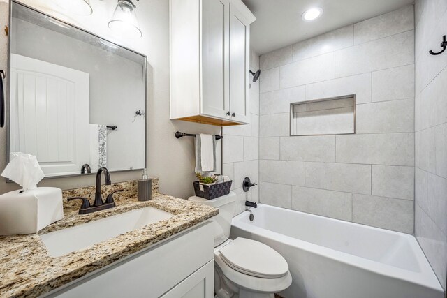 full bathroom featuring vanity, toilet, and tiled shower / bath