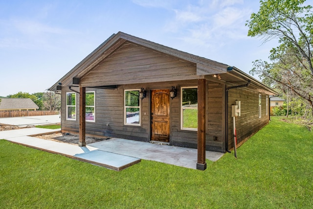 rear view of property featuring a lawn and a patio area