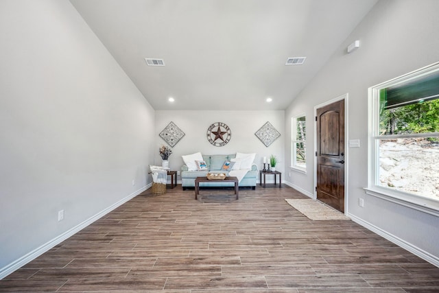 unfurnished room featuring lofted ceiling and hardwood / wood-style flooring