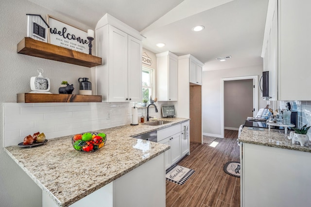 kitchen with white cabinetry, light stone counters, tasteful backsplash, dark hardwood / wood-style floors, and sink