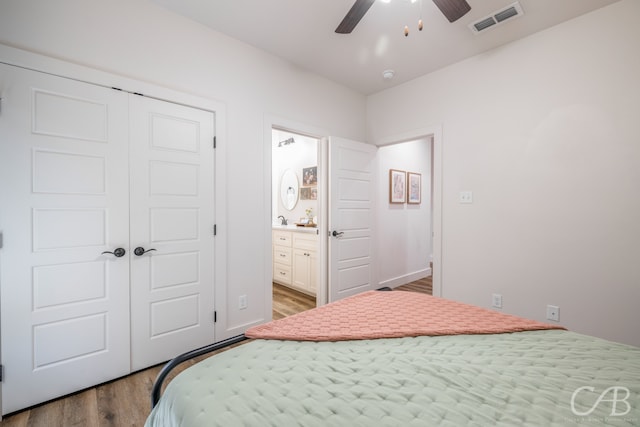 bedroom featuring hardwood / wood-style floors, ceiling fan, a closet, and ensuite bath