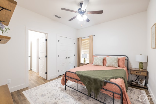 bedroom with wood-type flooring, ceiling fan, and a closet