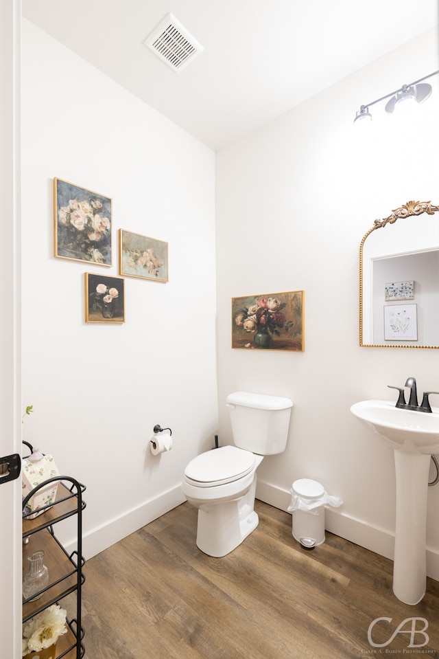 bathroom featuring hardwood / wood-style flooring and toilet