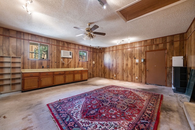 misc room with a textured ceiling, ceiling fan, and a wall unit AC