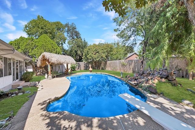 view of pool with a diving board, a yard, and a patio area