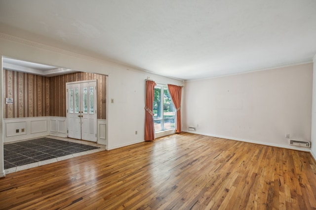 unfurnished room featuring wood-type flooring and ornamental molding