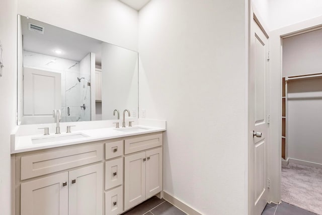 bathroom featuring a shower with shower door, vanity, and tile patterned floors