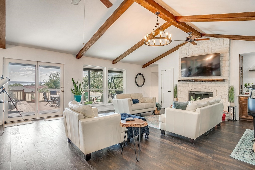 living room featuring ceiling fan with notable chandelier, lofted ceiling with beams, dark wood-type flooring, and a fireplace