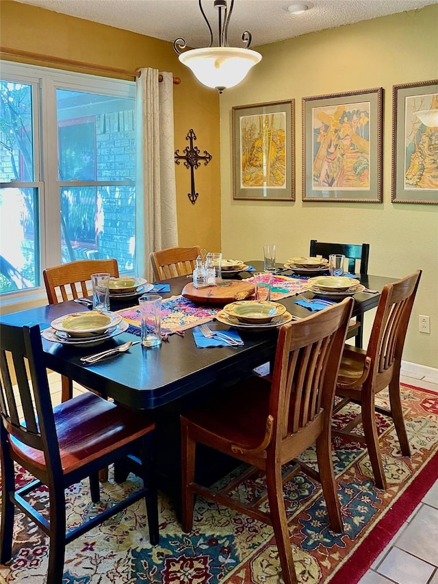 dining room with a textured ceiling and light tile patterned flooring