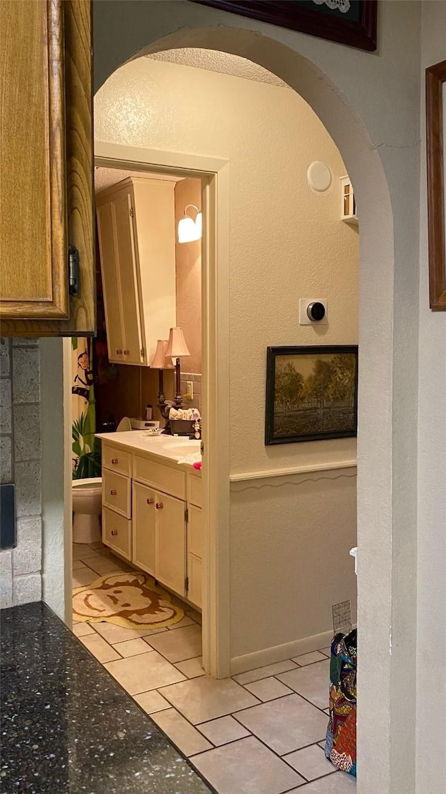 bathroom featuring tile patterned floors, vanity, and toilet