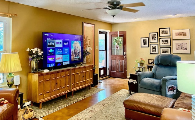 living room featuring hardwood / wood-style flooring, plenty of natural light, ceiling fan, and a textured ceiling