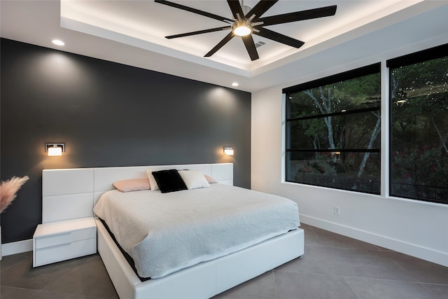 bedroom featuring a tray ceiling, ceiling fan, and tile patterned floors