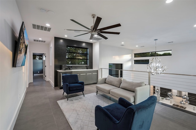 living room featuring ceiling fan with notable chandelier