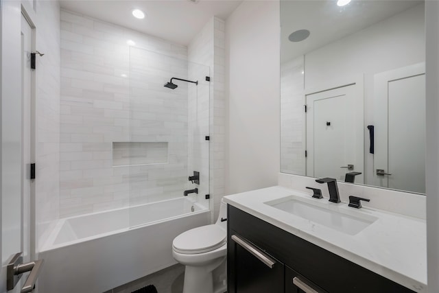 full bathroom featuring vanity, tiled shower / bath combo, and toilet