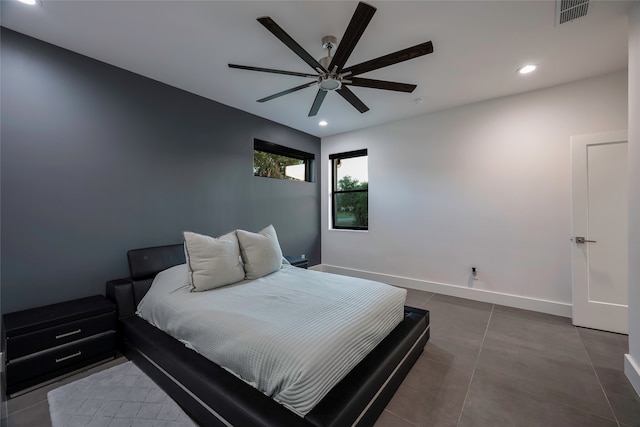 bedroom with ceiling fan and dark tile patterned floors