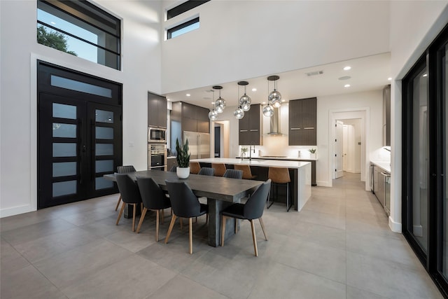 dining room featuring a high ceiling, sink, and french doors