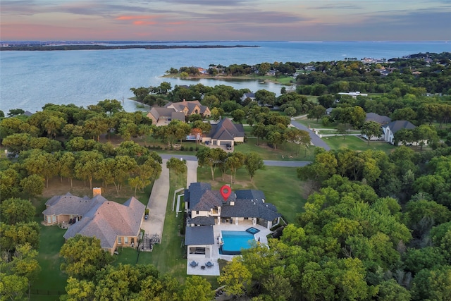 aerial view at dusk featuring a water view