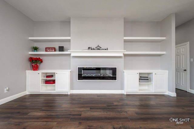 unfurnished living room featuring built in features and dark wood-type flooring