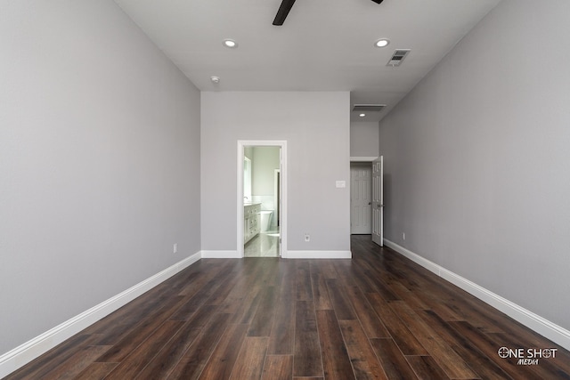 unfurnished bedroom featuring ensuite bathroom, ceiling fan, and dark wood-type flooring