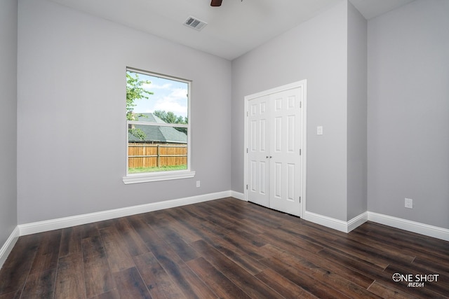 unfurnished bedroom with ceiling fan, a closet, and dark hardwood / wood-style floors