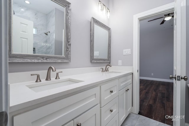 bathroom with vanity, ceiling fan, a shower, and wood-type flooring