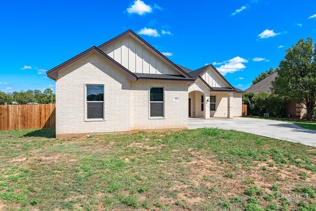 802 Waters Edge Dr, Abilene, TX 79602 - view of front facade featuring board and batten siding, brick siding, fence, and a front yard