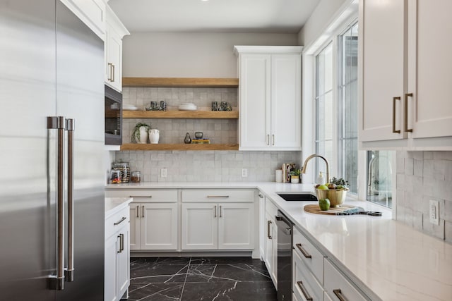 1644 Aster Way, Celina, TX 75009 - kitchen featuring built in appliances, a sink, dark marble finish floors, backsplash, and white cabinets