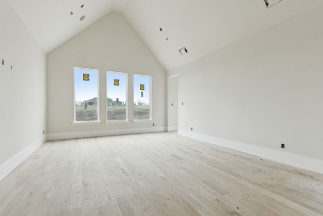 unfurnished living room with light hardwood / wood-style floors and high vaulted ceiling