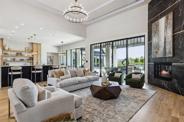 1644 Aster Way, Celina, TX 75009 - living room with light wood-type flooring, a chandelier, plenty of natural light, recessed lighting, and a high end fireplace