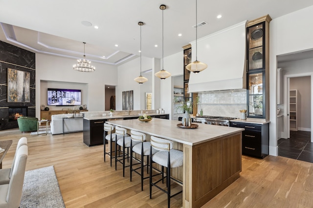 1644 Aster Way, Celina, TX 75009 - kitchen featuring a breakfast bar, light wood-style flooring, a peninsula, a large island, and pendant lighting