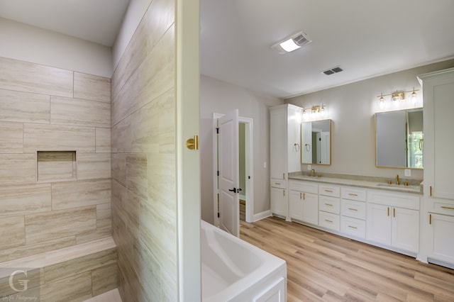 bathroom with vanity, hardwood / wood-style floors, and a bathing tub