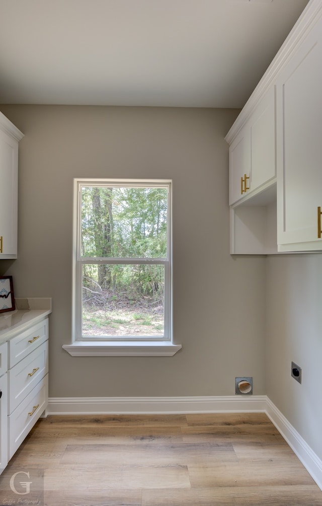 washroom with cabinets, light wood-type flooring, and electric dryer hookup