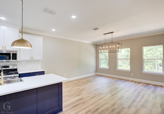 kitchen featuring appliances with stainless steel finishes, white cabinets, crown molding, and decorative backsplash