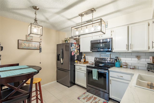 kitchen with pendant lighting, white cabinetry, appliances with stainless steel finishes, and backsplash