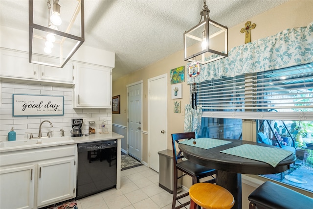 kitchen featuring white cabinets, black dishwasher, decorative light fixtures, and sink