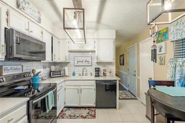 kitchen with appliances with stainless steel finishes, hanging light fixtures, white cabinetry, light tile patterned floors, and sink