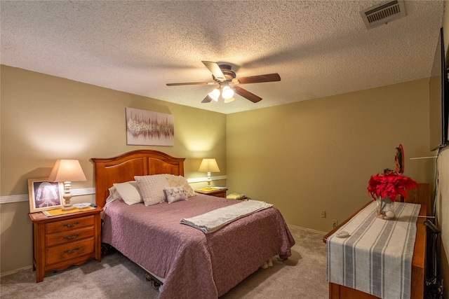 bedroom featuring ceiling fan, a textured ceiling, and light carpet