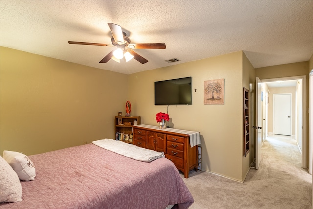 carpeted bedroom with a textured ceiling and ceiling fan