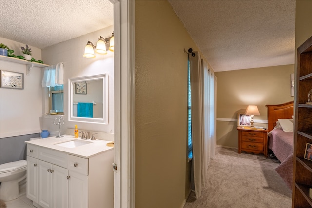 bathroom with vanity, toilet, and a textured ceiling