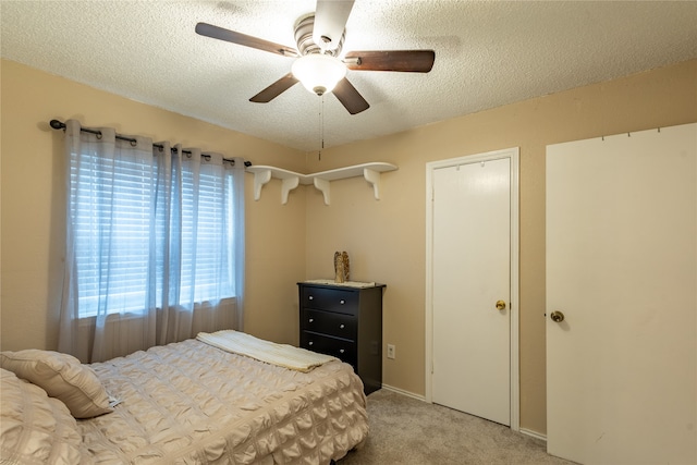 carpeted bedroom with ceiling fan and a textured ceiling