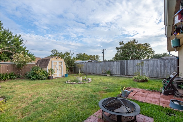 view of yard featuring a storage unit and an outdoor fire pit