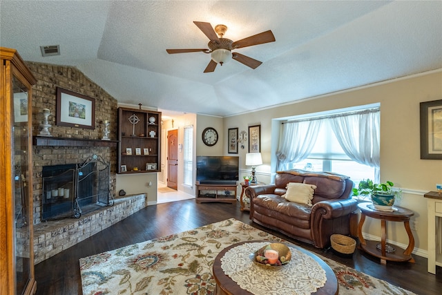 living room featuring vaulted ceiling, ceiling fan, a fireplace, and dark wood-type flooring