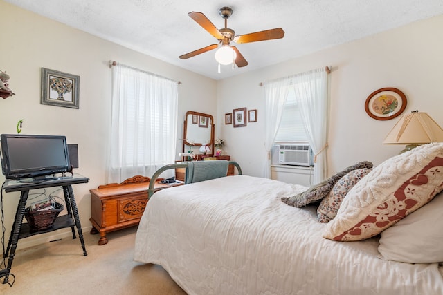 bedroom with a textured ceiling, cooling unit, ceiling fan, and light colored carpet