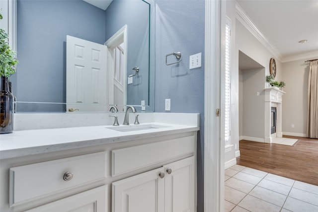 bathroom with vanity, hardwood / wood-style flooring, and crown molding