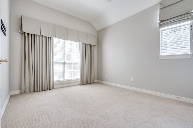 unfurnished room featuring carpet flooring, vaulted ceiling, and plenty of natural light