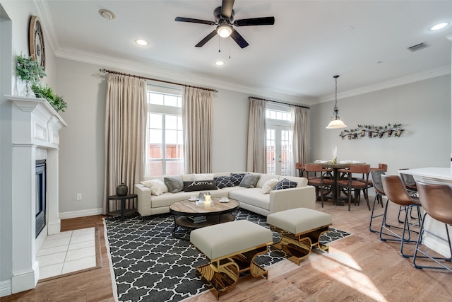 dining space with ceiling fan, crown molding, and light hardwood / wood-style flooring